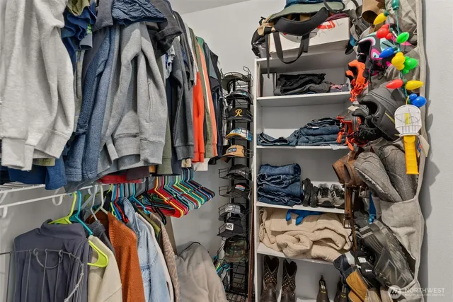 a view of walk in closet with clothes and shoes