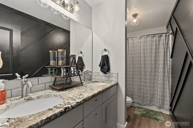 a bathroom with a granite countertop sink and a mirror