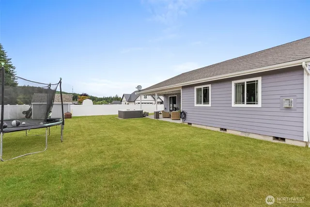 a view of a swimming pool with a patio and a yard