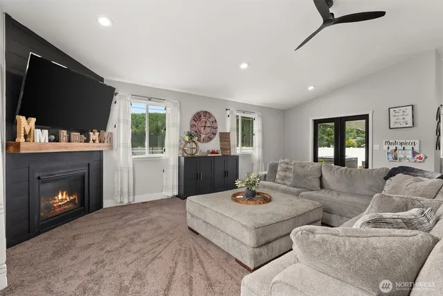 a living room with furniture a flat screen tv and a fireplace