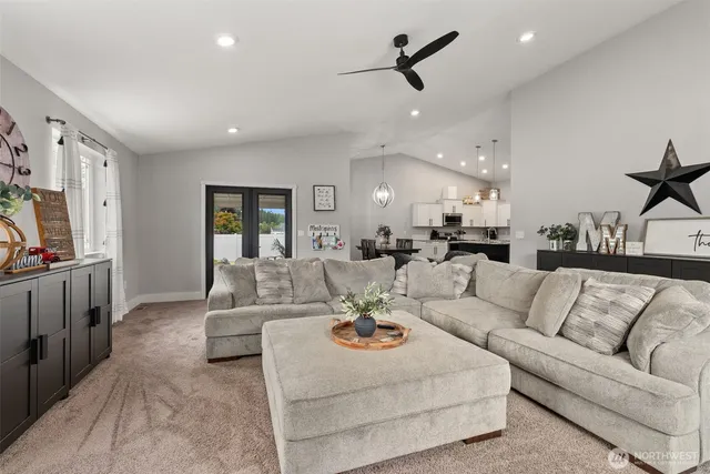 a living room with furniture kitchen view and a chandelier