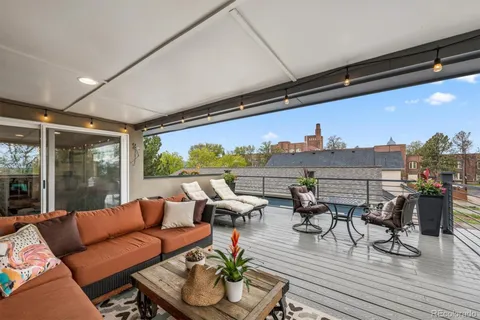 a roof deck with couches and wooden floor