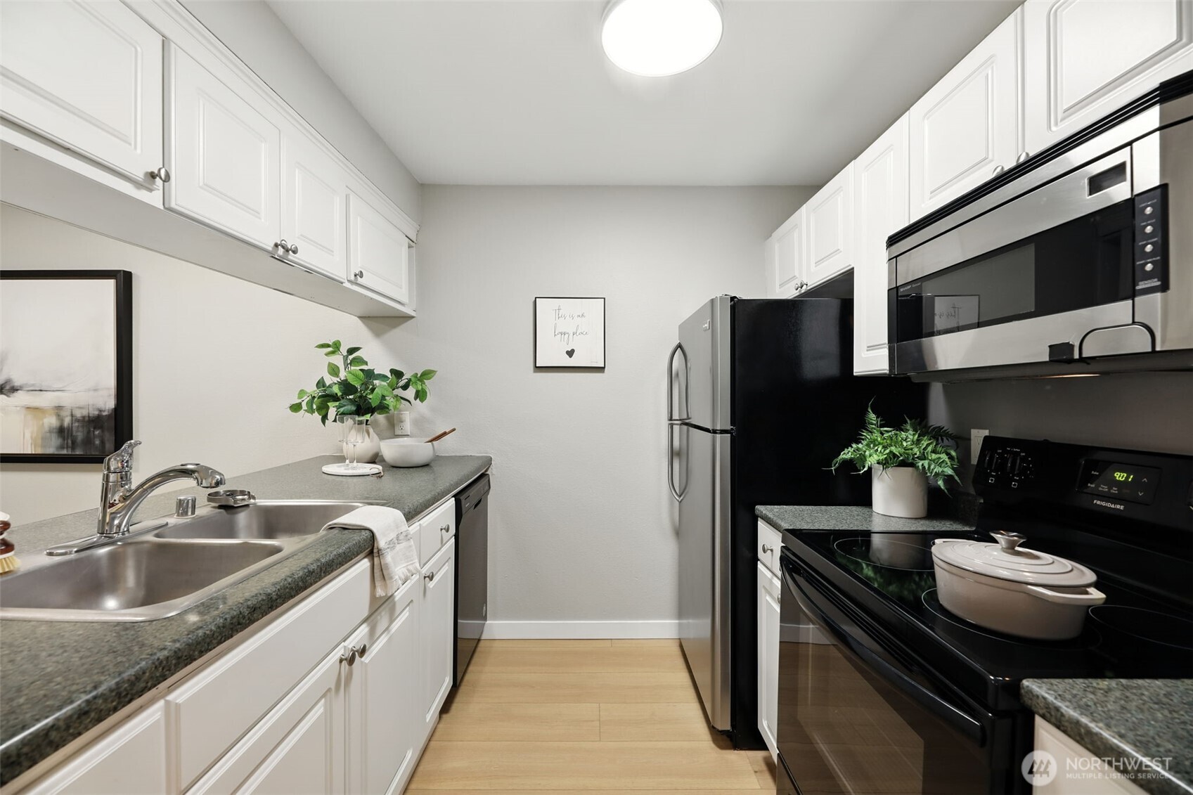3233 Northeast 12th Street, Unit 207 Renton, WA 98056 - Photo 14 of 40 a kitchen with stainless steel appliances granite countertop a sink refrigerator and microwave