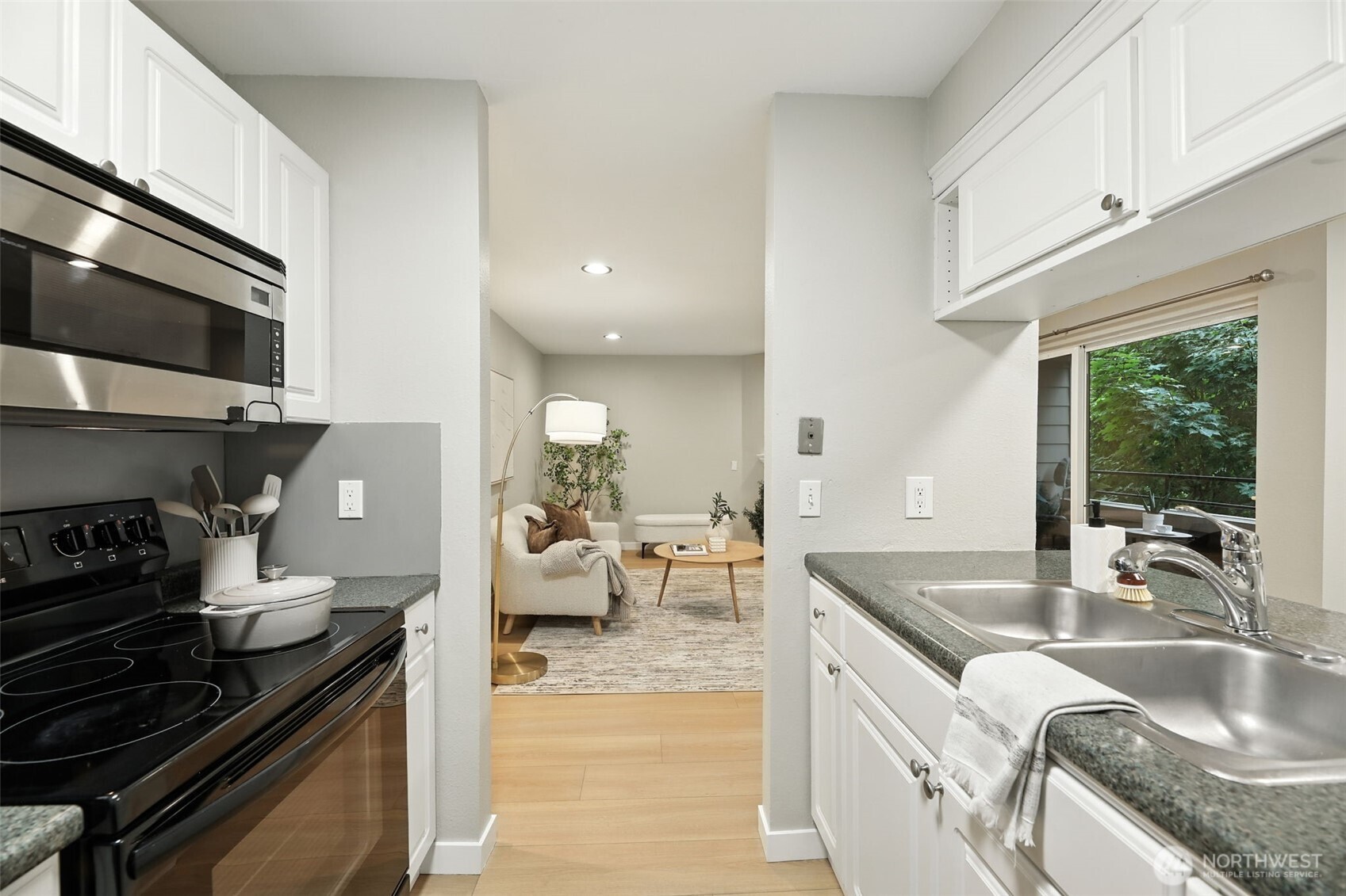 3233 Northeast 12th Street, Unit 207 Renton, WA 98056 - Photo 16 of 40 a kitchen with stainless steel appliances granite countertop a sink stove and cabinets