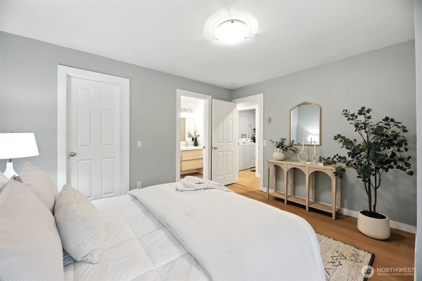 3233 Northeast 12th Street, Unit 207 Renton, WA 98056 - Photo 17 of 40 a bedroom with a large bed a potted plant and a fireplace
