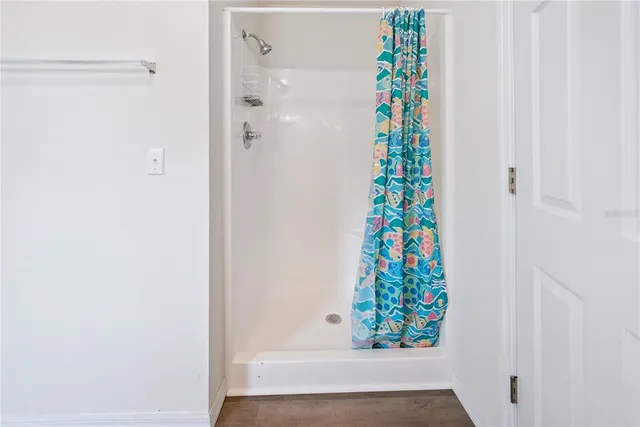 a bedroom with bed and wooden floor