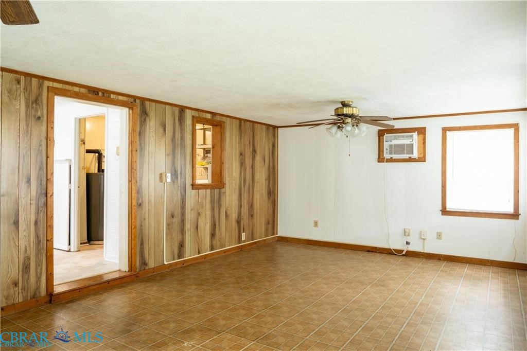 1008 Mill Creek Road Wake, VA 23176 - Photo 17 of 22 Spare room with a ceiling fan, ornamental molding, wood walls, and a wall unit AC