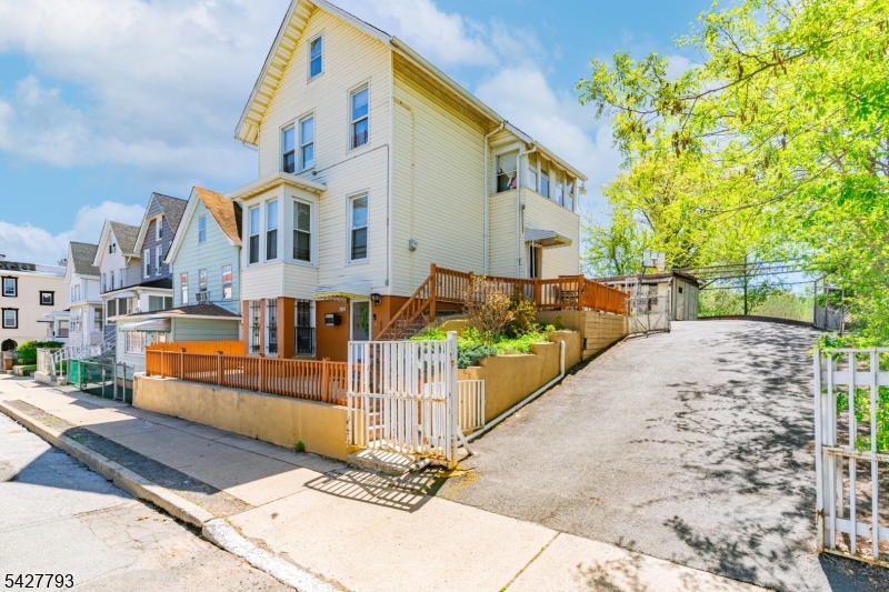 420 Mechanic Street Orange, NJ 07050 - Photo 14 of 18 a view of a white house with large windows and a small yard