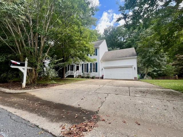 a front view of a house with a yard and trees