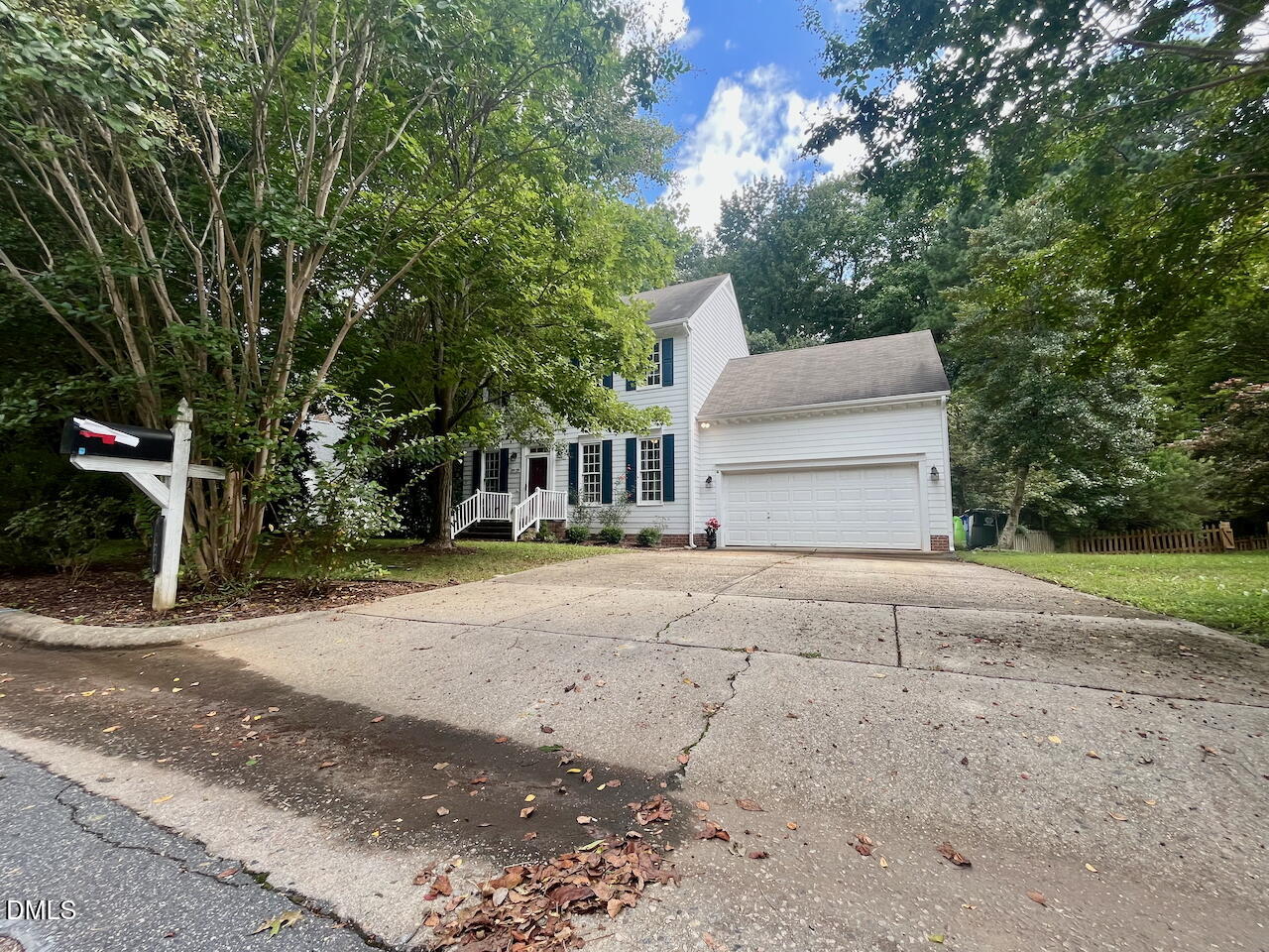 a front view of a house with a yard and trees