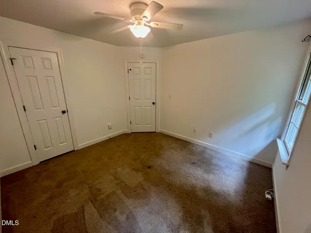 an empty room with a chandelier fan