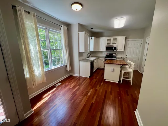 a kitchen with stainless steel appliances a stove top oven a sink and a microwave