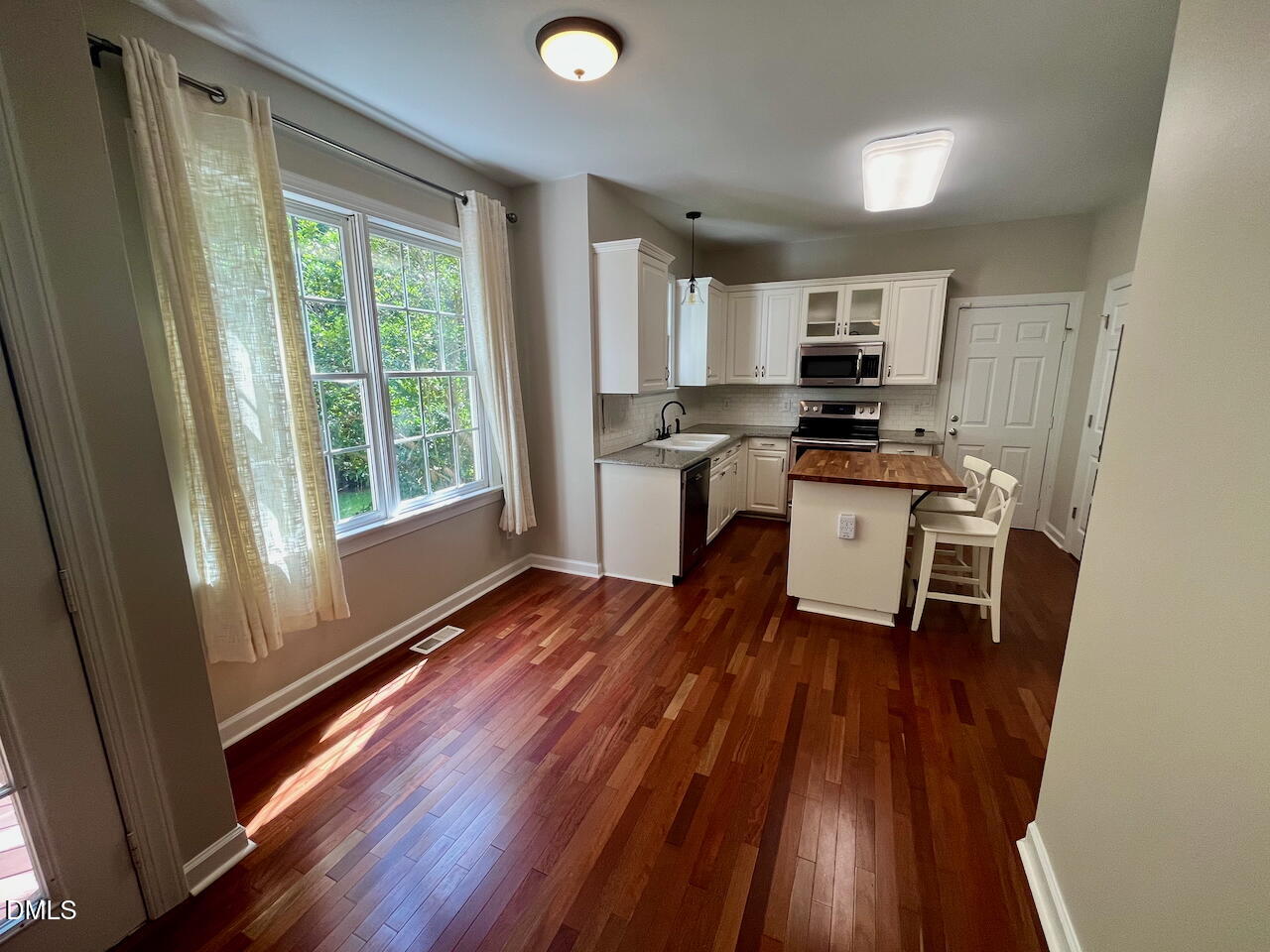 8528 Yucca Trail Raleigh, NC 27615 - Photo 8 of 25 a kitchen with stainless steel appliances a stove top oven a sink and a microwave