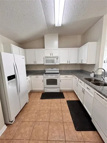 a kitchen with stainless steel appliances granite countertop a refrigerator sink and cabinets