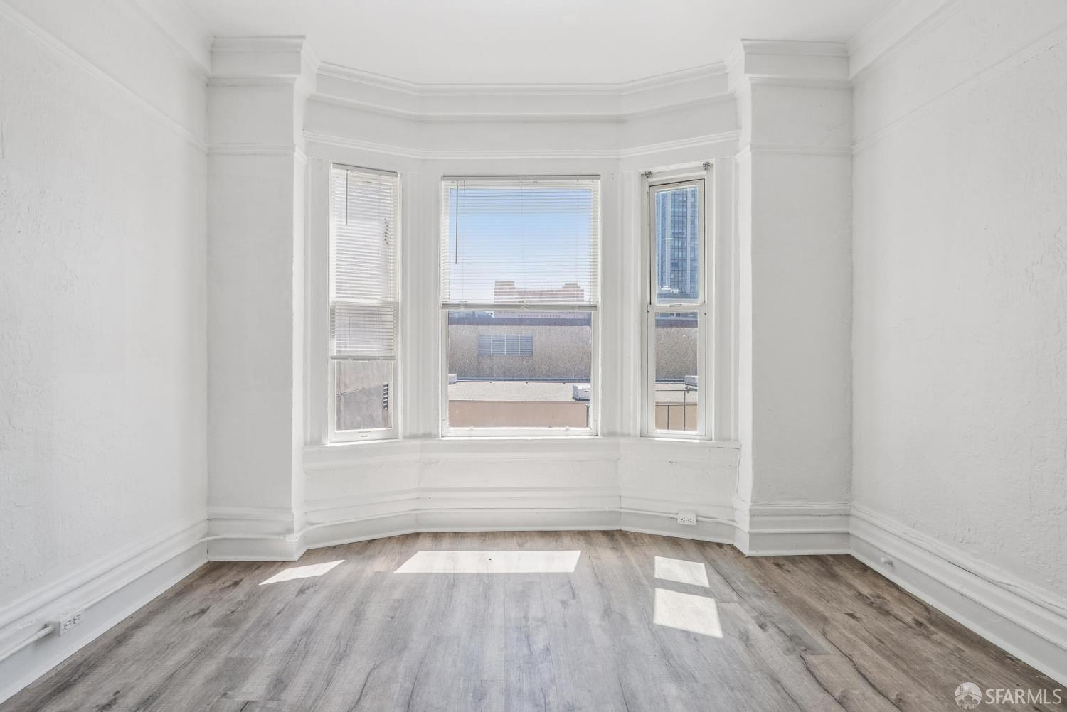 669 Ellis Street San Francisco, CA 94109 - Photo 11 of 32 a view of an empty room with wooden floor and a window