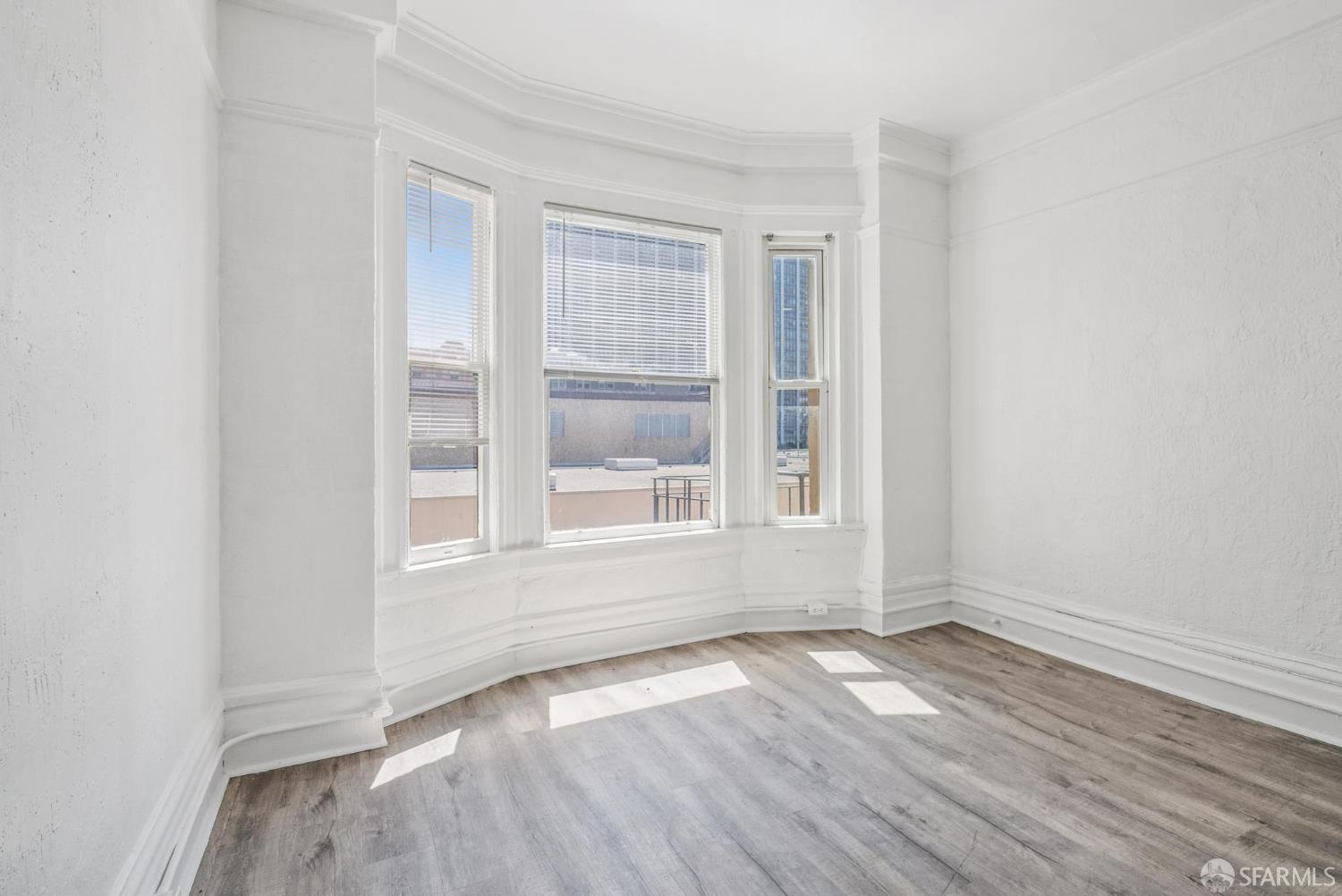 669 Ellis Street San Francisco, CA 94109 - Photo 12 of 32 an empty room with wooden floor and windows