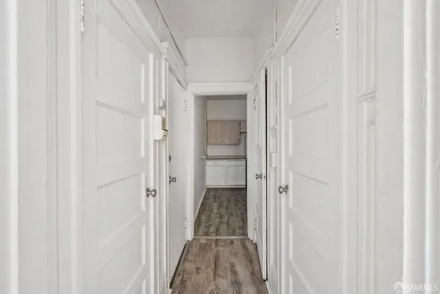 a kitchen with a refrigerator a stove top oven and wooden floor