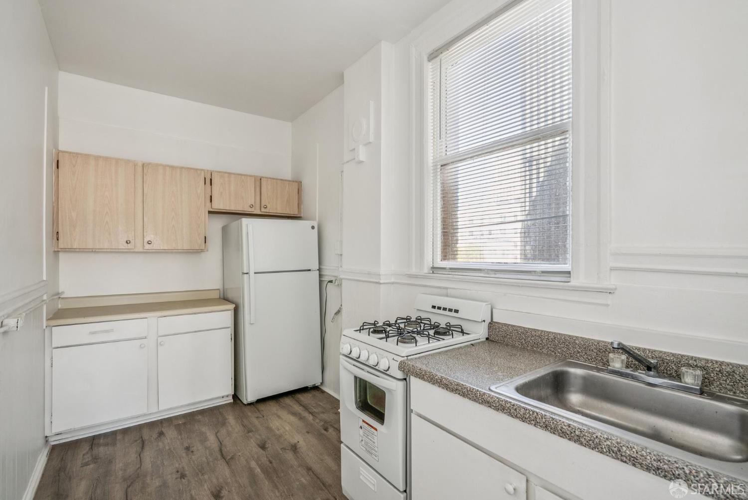 669 Ellis Street San Francisco, CA 94109 - Photo 15 of 32 a kitchen with a refrigerator stove and white cabinets