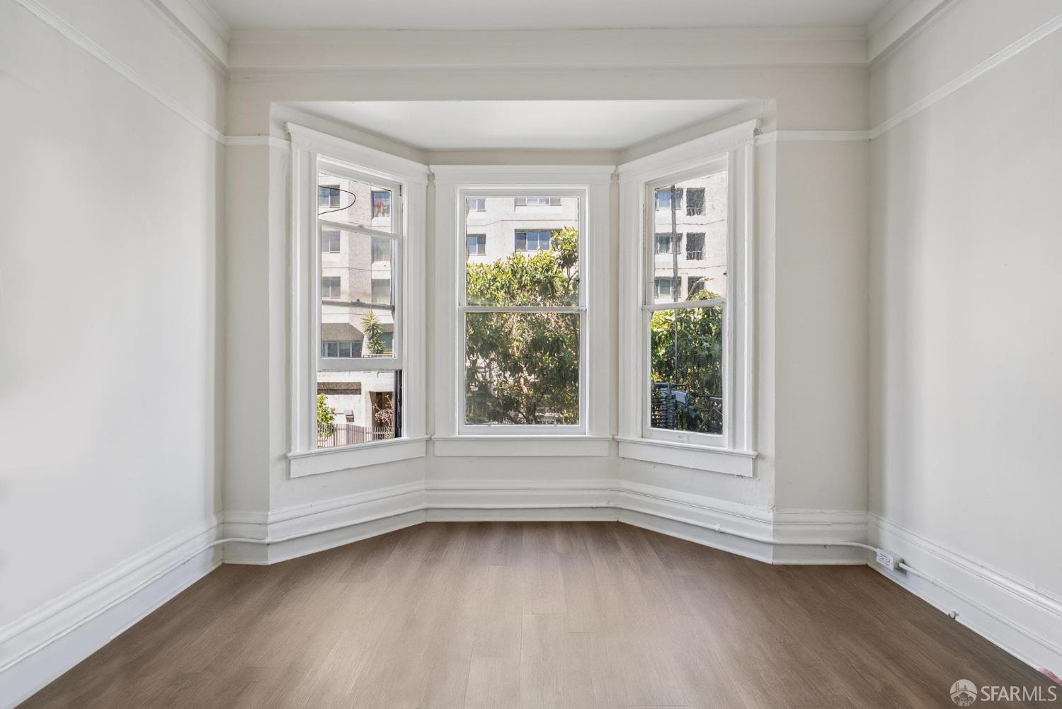 669 Ellis Street San Francisco, CA 94109 - Photo 22 of 32 an empty room with wooden floor and windows