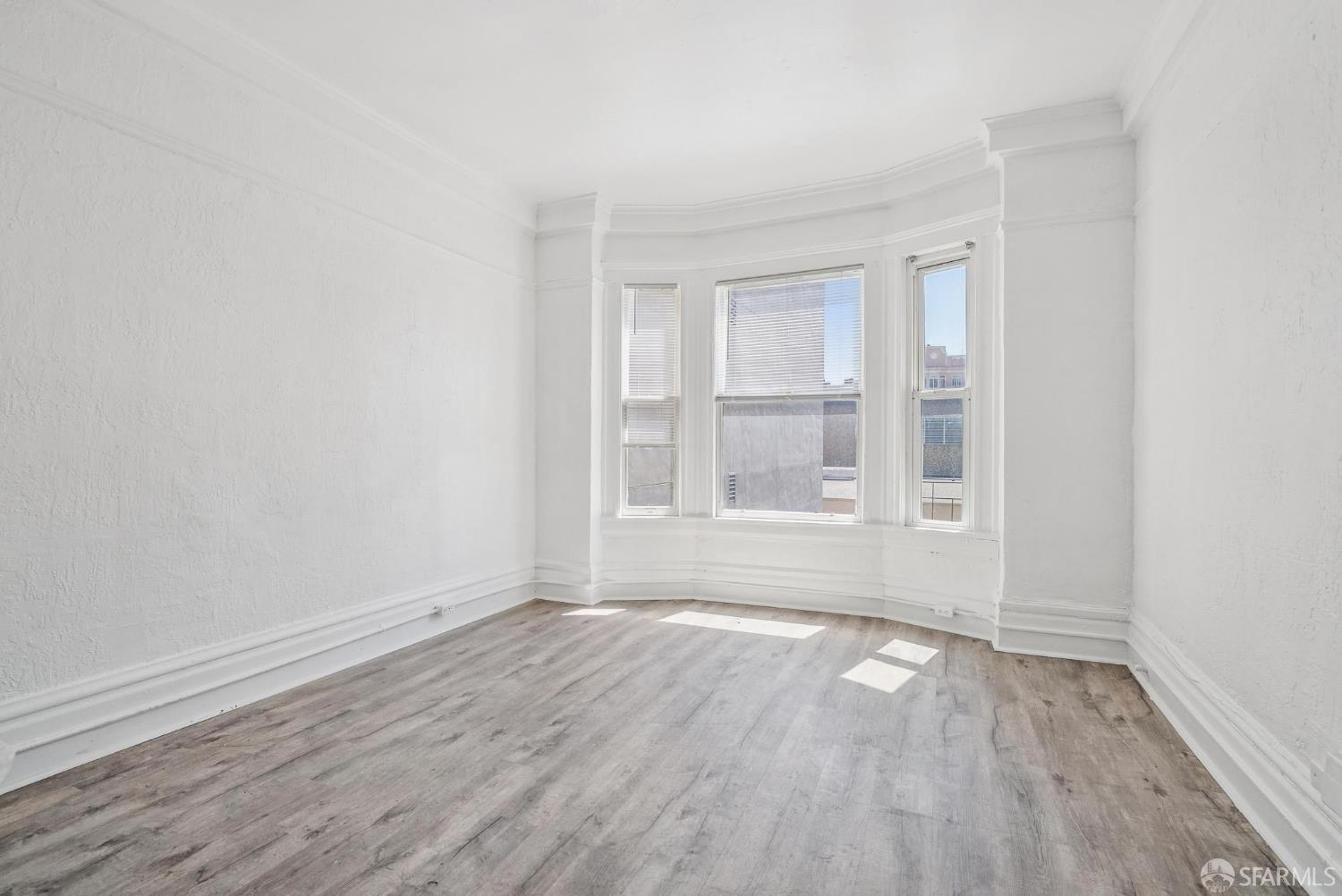 669 Ellis Street San Francisco, CA 94109 - Photo 10 of 32 an empty room with wooden floor and windows