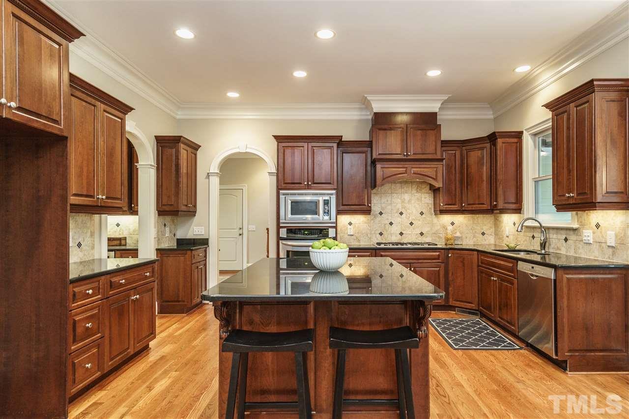 1801 Bowling Green Trail Raleigh, NC 27613 - Photo 8 of 25 a kitchen with granite countertop wooden cabinets and stainless steel appliances