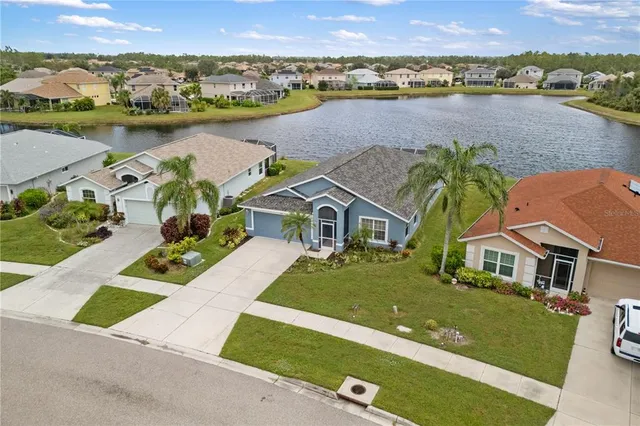 an aerial view of a house with outdoor space and lake view