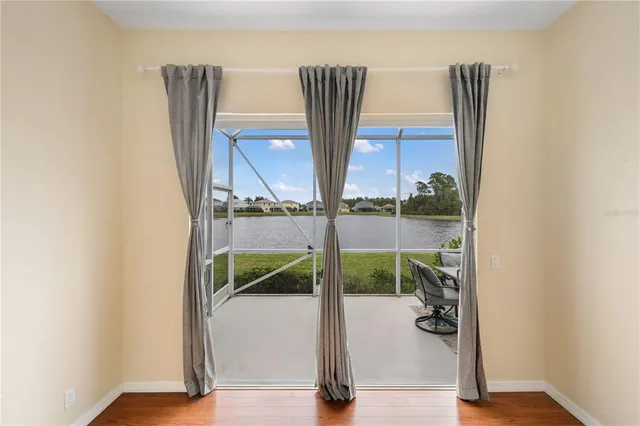 a view of a hallway with wooden floor and a bathroom