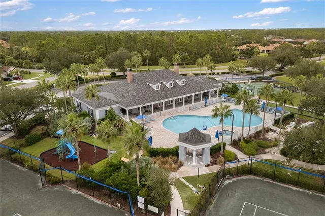 an aerial view of residential houses with outdoor space and swimming pool