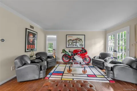 a living room with furniture and a flat screen tv with wooden floor
