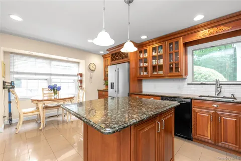 a kitchen with stainless steel appliances granite countertop a kitchen island a stove and a sink