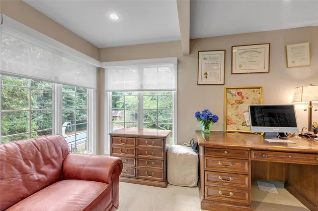 a living room with furniture flat screen tv and a large window
