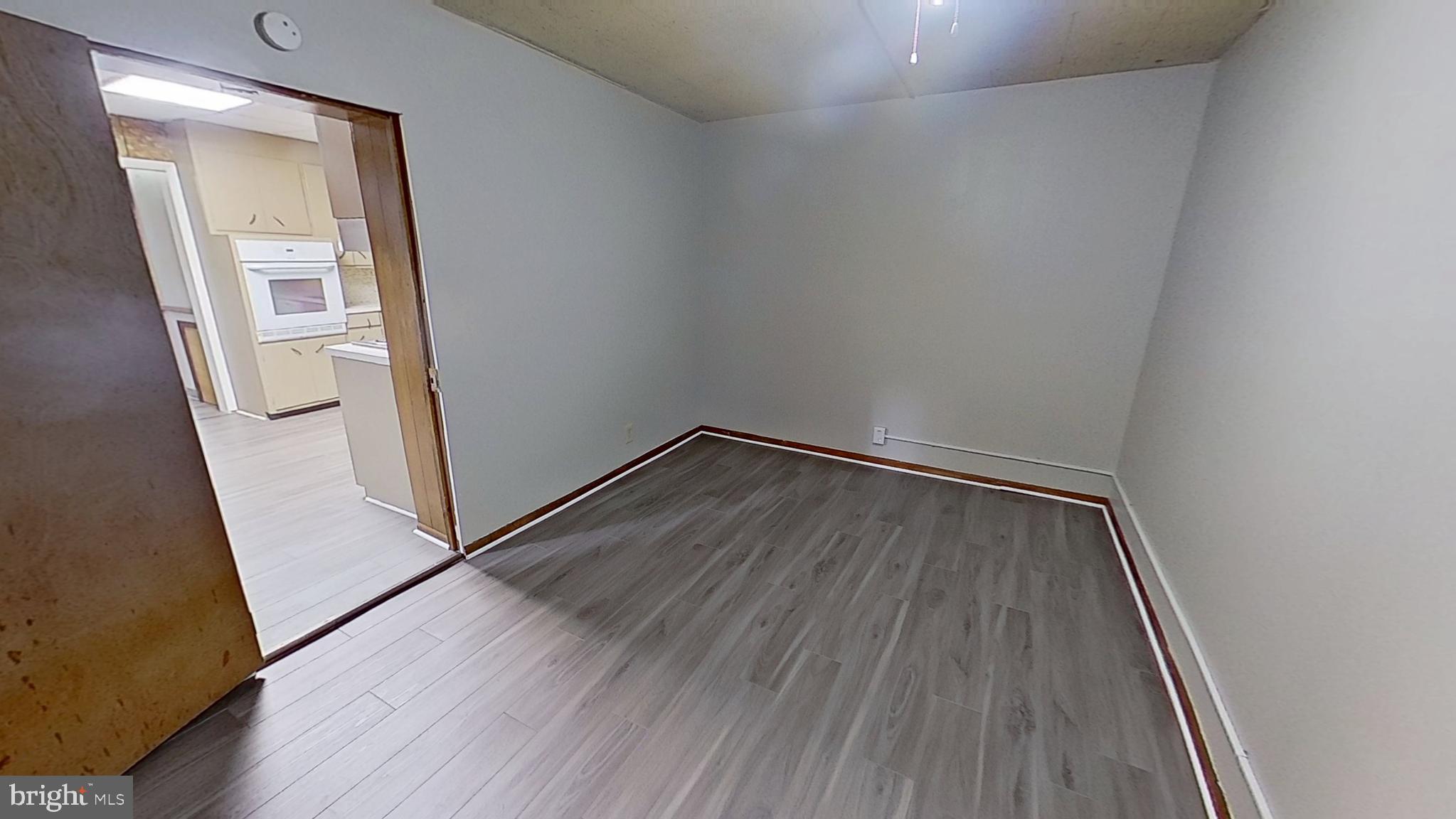 648 Broadway, Unit E Hanover, PA 17331 - Photo 11 of 12 an empty room with wooden floor and entrance