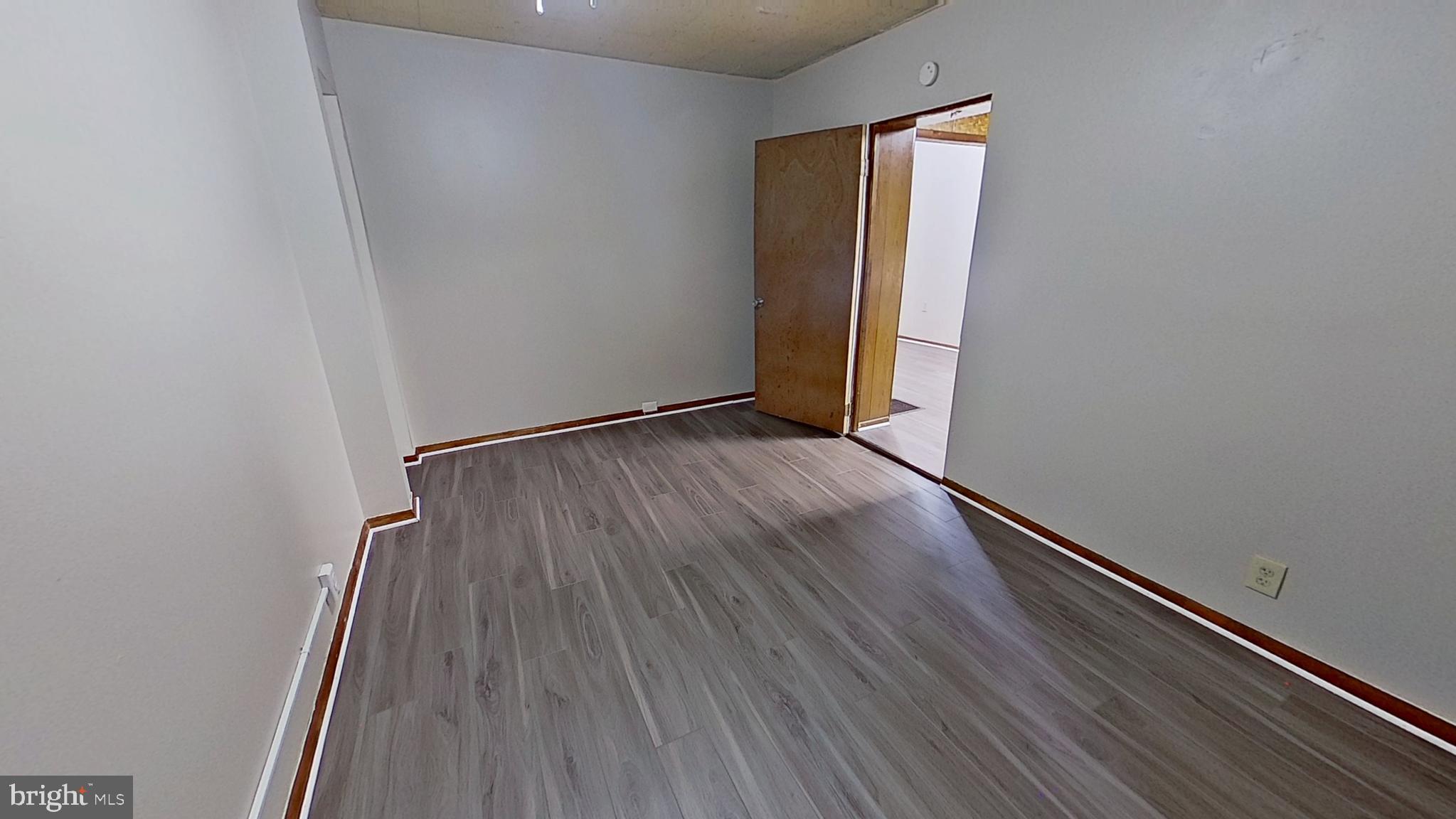 648 Broadway, Unit E Hanover, PA 17331 - Photo 12 of 12 an empty room with wooden floor and windows