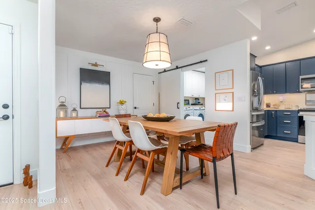 a kitchen with kitchen island granite countertop stainless steel appliances a sink counter space and a refrigerator