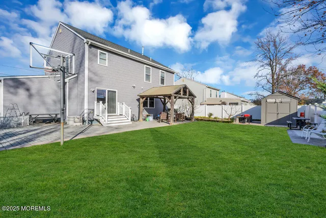 a view of a white house in front of a big yard
