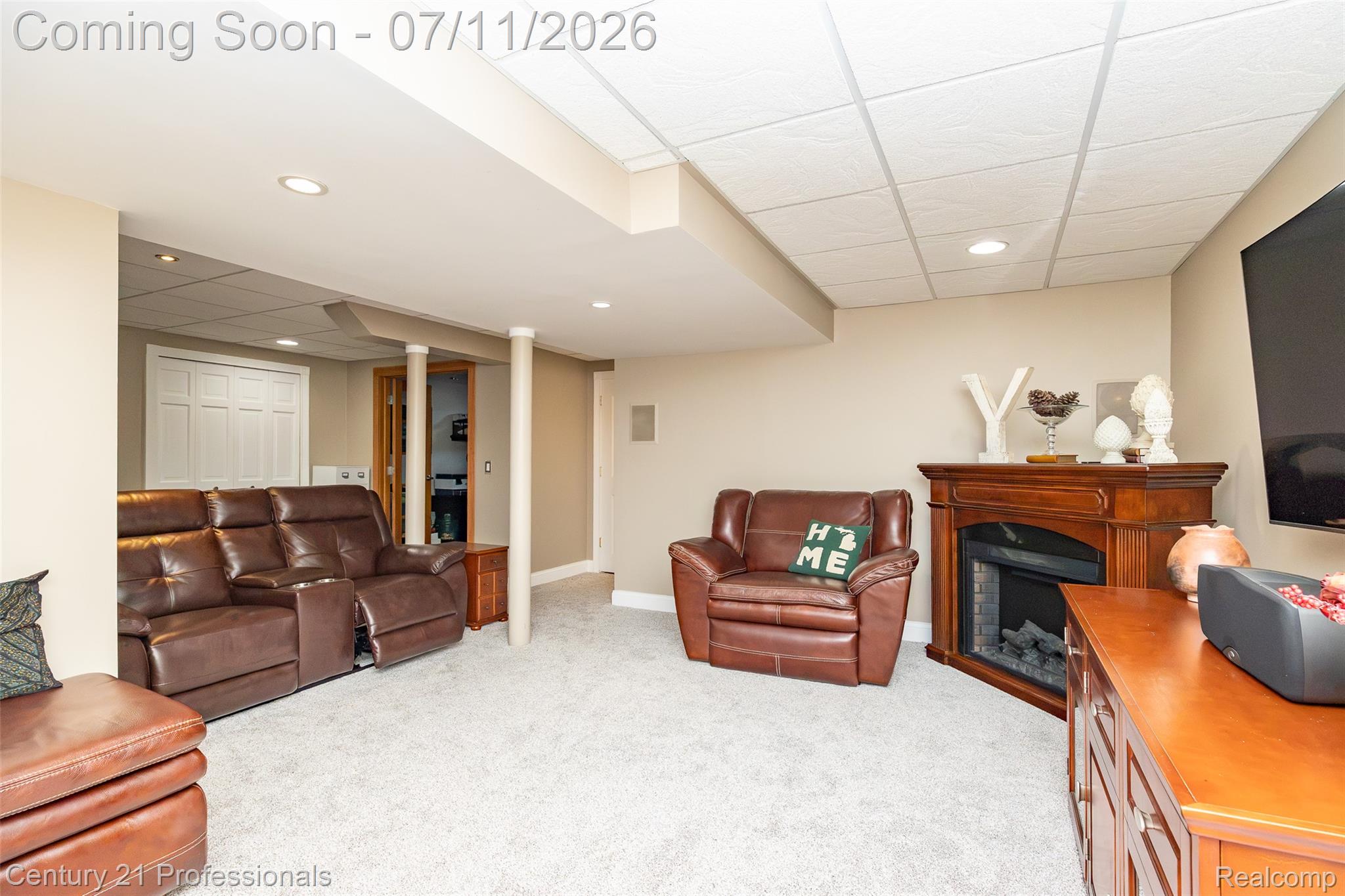 689 Woodfield Way Rochester, MI 48307 - Photo 44 of 61 Finished basement featuring recessed lighting, light-toned carpeting, a corner fireplace with wood-tone mantel, and a drop ceiling