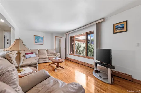 a living room with furniture wooden floor and a large window