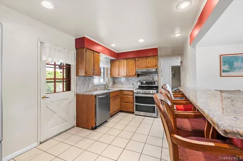 a kitchen with stainless steel appliances granite countertop a sink and a stove