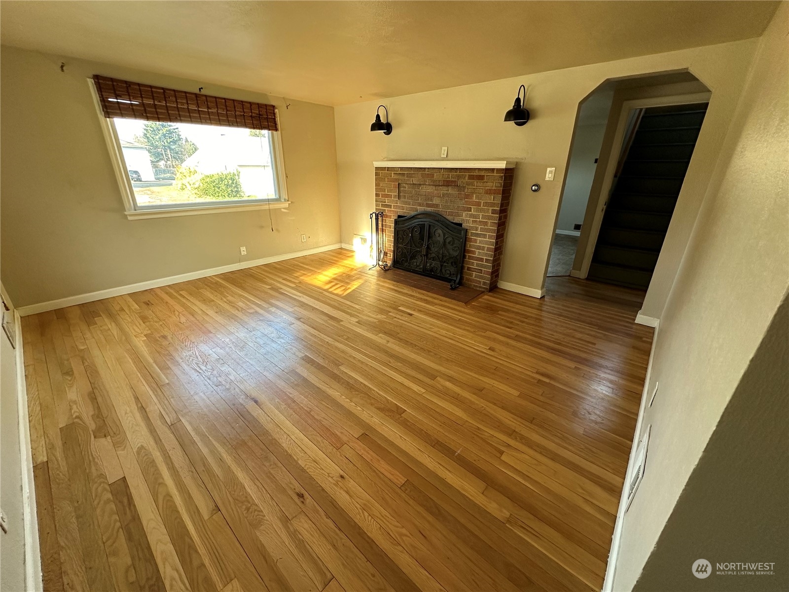 715 Thompson Street Sumner, WA 98390 - Photo 4 of 6 a view of empty room with a fireplace and wooden floor