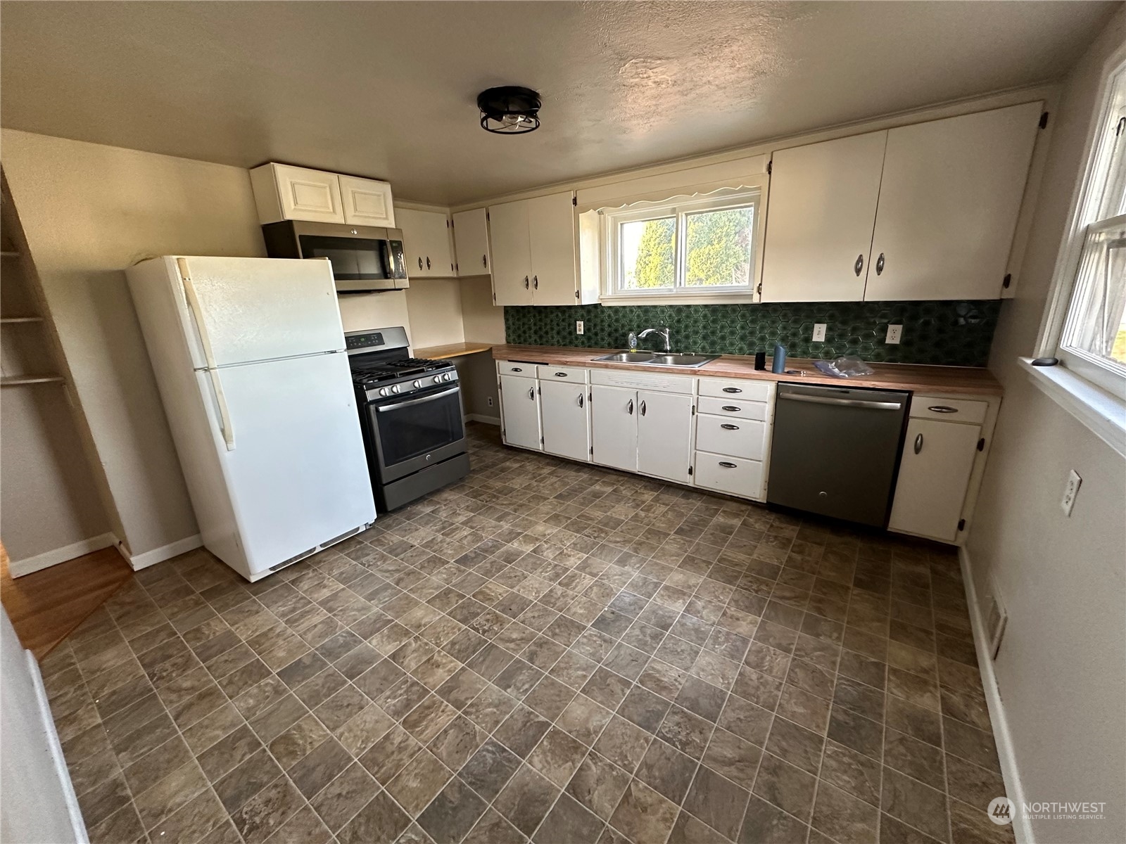 715 Thompson Street Sumner, WA 98390 - Photo 5 of 6 a kitchen with a refrigerator sink and cabinets