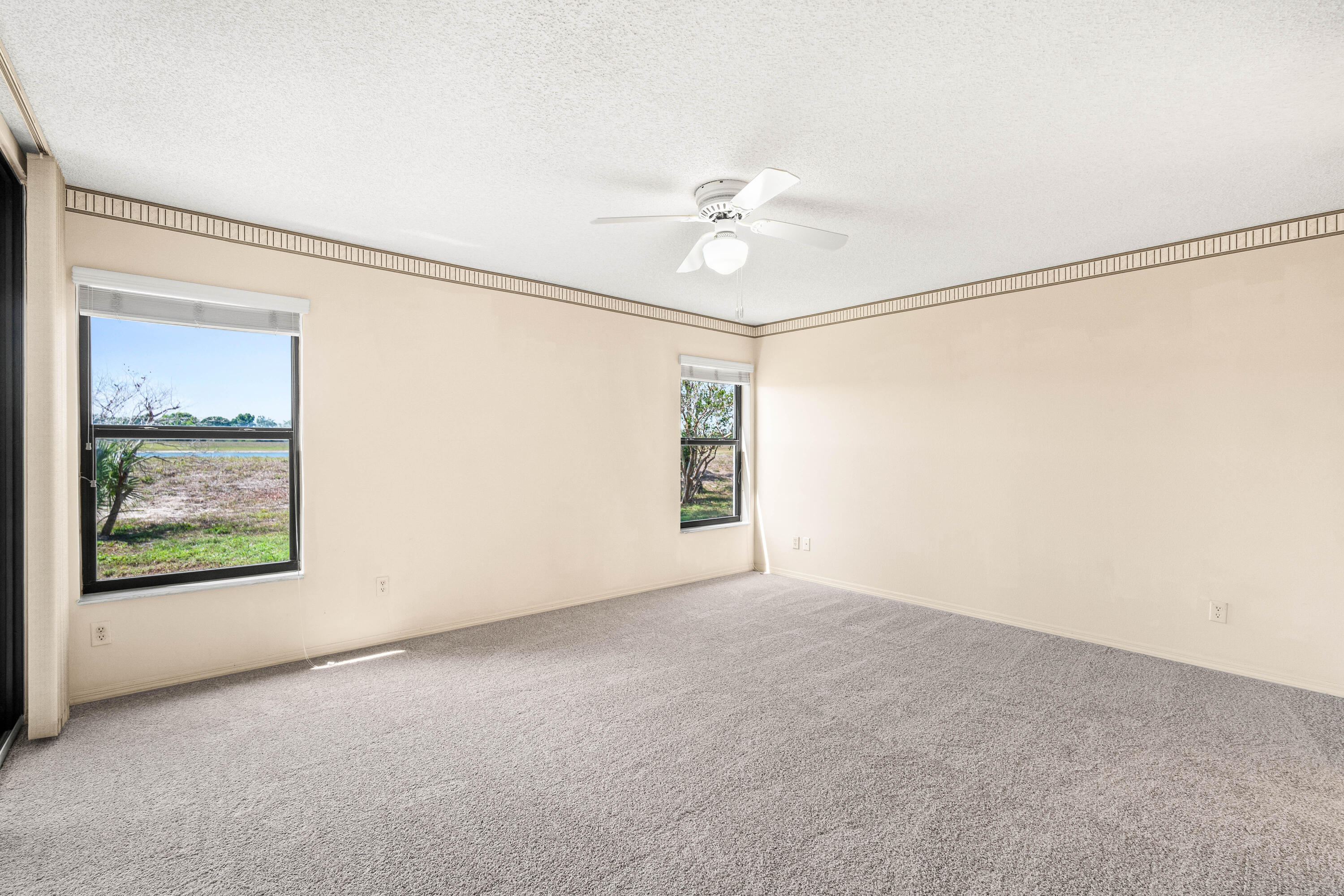 10920 Lakemore Lane, Unit 101 Boca Raton, FL 33498 - Photo 25 of 41 an empty room with windows and fan