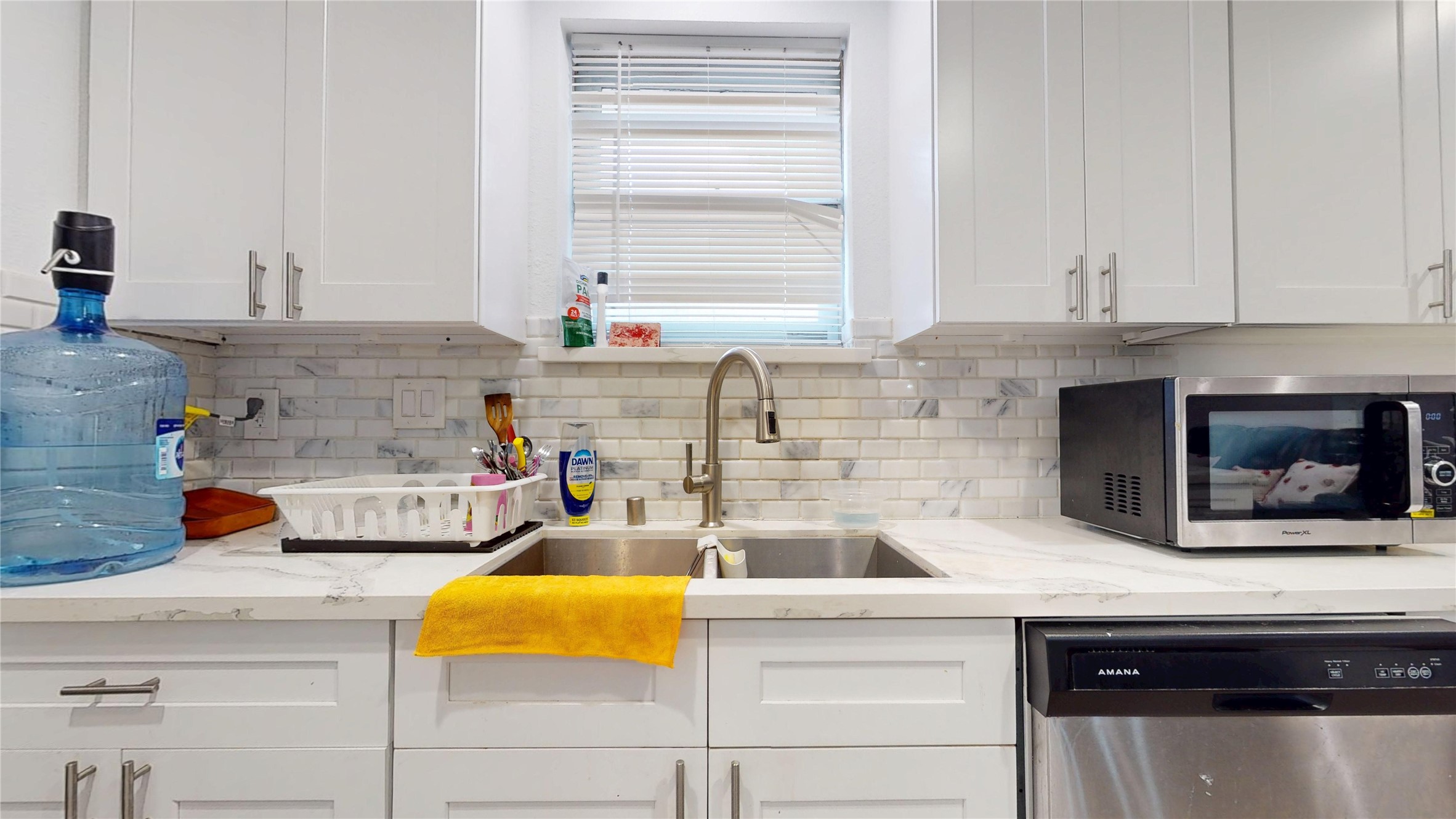 827 Dondell Street Channelview, TX 77530 - Photo 13 of 49 827 Dondell St, Stainless steal sink and hardware with white cabinets, quarts countertops and white/gay backsplash tile.