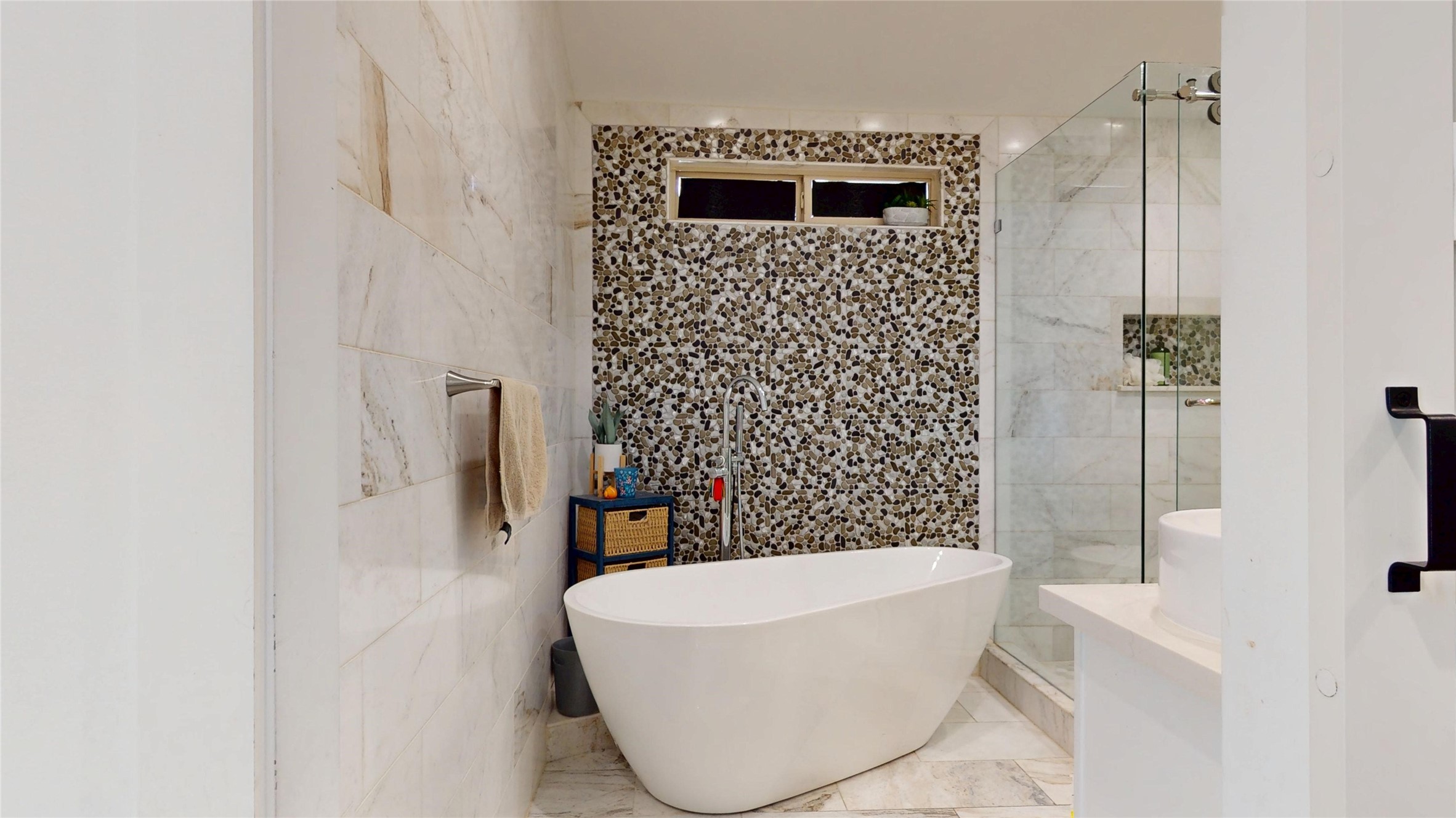 827 Dondell Street Channelview, TX 77530 - Photo 26 of 49 827 Dondell St, Primary bathroom, oval free standing soaking bathtub, standing shower, marble floording and walls, with accent stone wall.