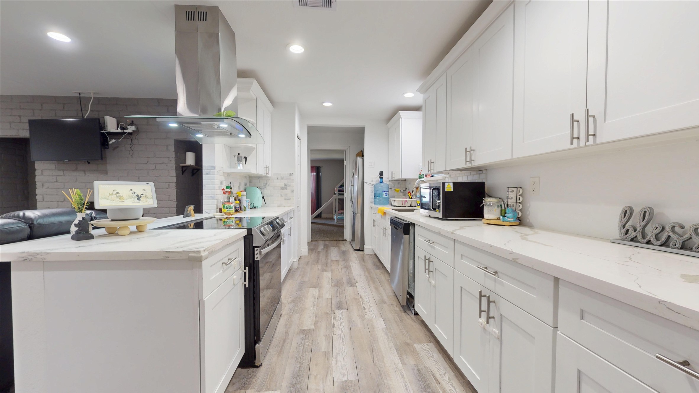 827 Dondell Street Channelview, TX 77530 - Photo 10 of 49 827 Dondell St, Kichen with stainless steal appliances, white cabinetry with quartz countertop and white tile backsplash.