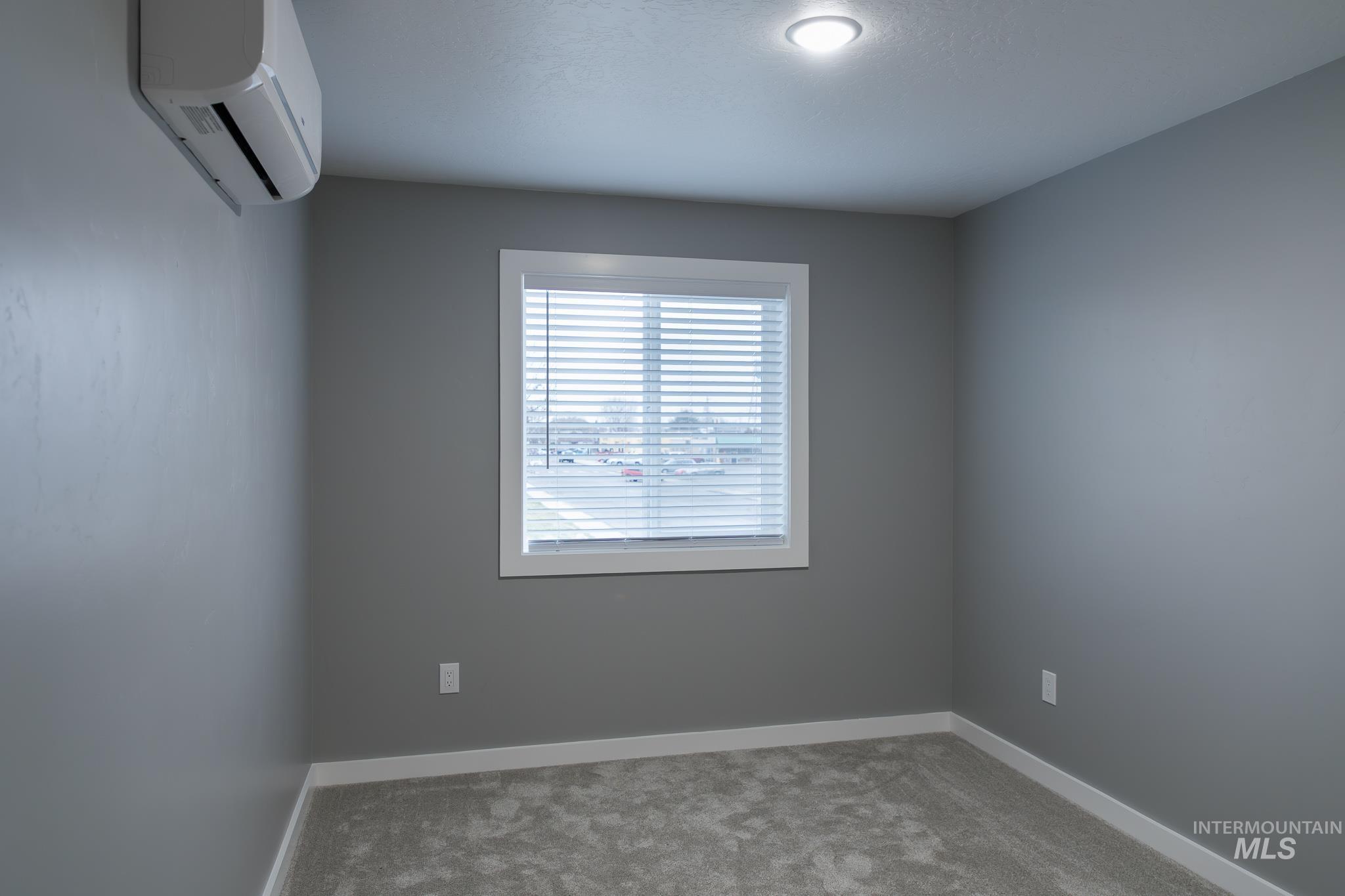 287 Southwest 6th Street, Unit 1 Ontario, OR 97914 - Photo 25 of 49 Carpeted spare room featuring a wall mounted mini split and baseboards