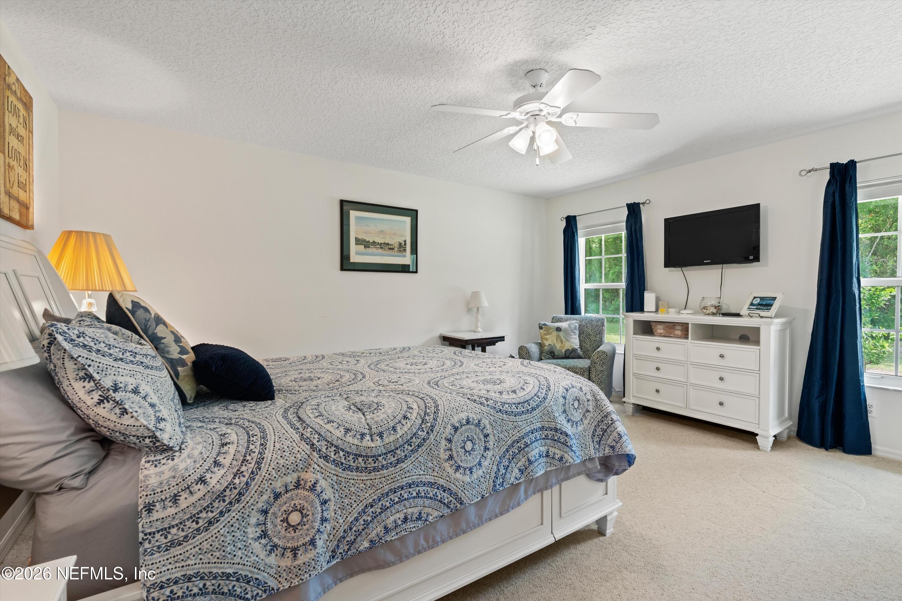 5566 Don Manuel Road Elkton, FL 32033 - Photo 27 of 47 a bedroom with a bed a couch and a flat screen tv