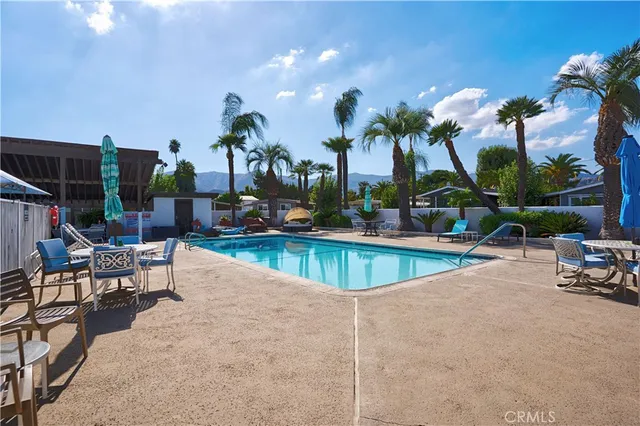 a view of a swimming pool with a patio and a yard