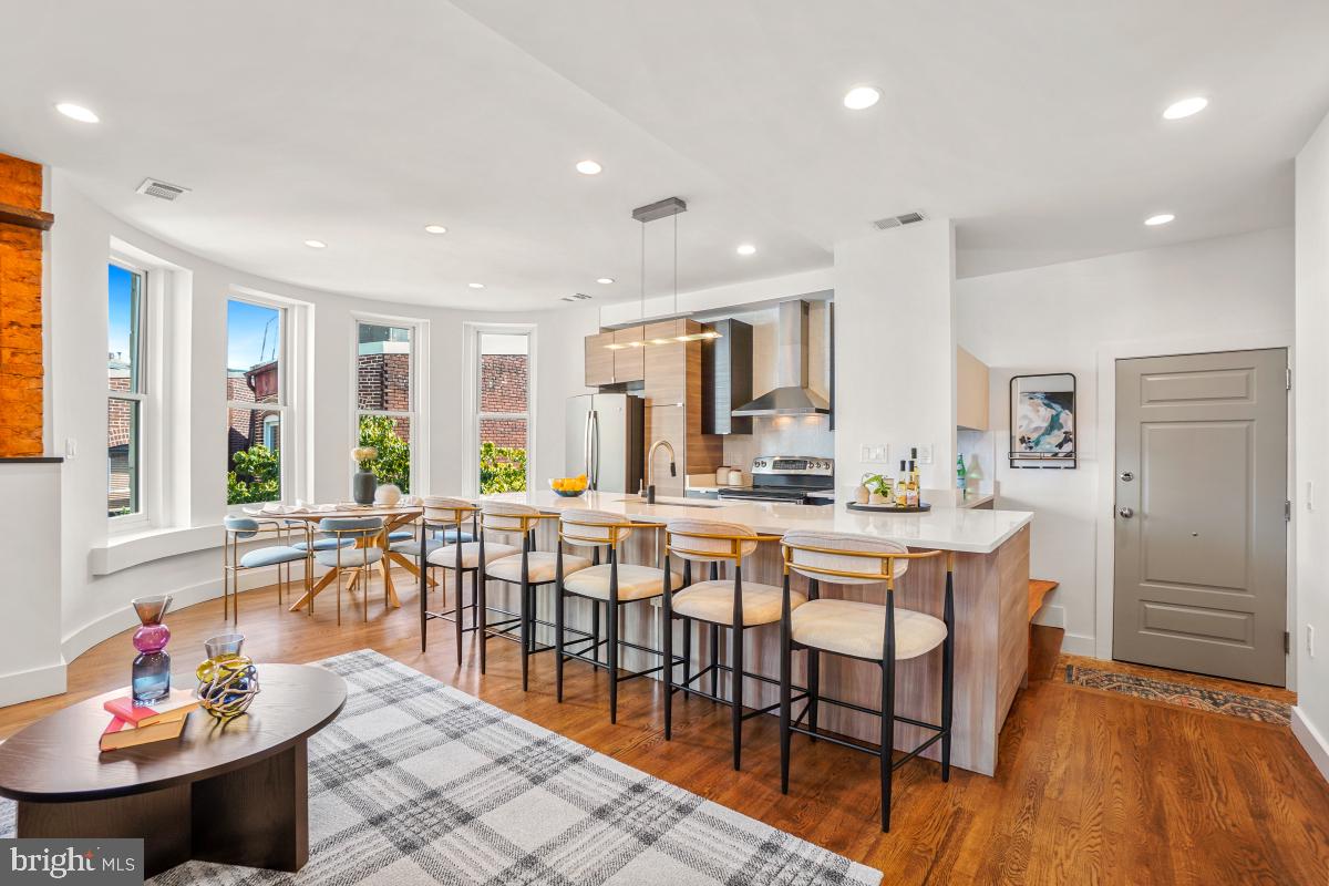 a large dining space with furniture window and wooden floor