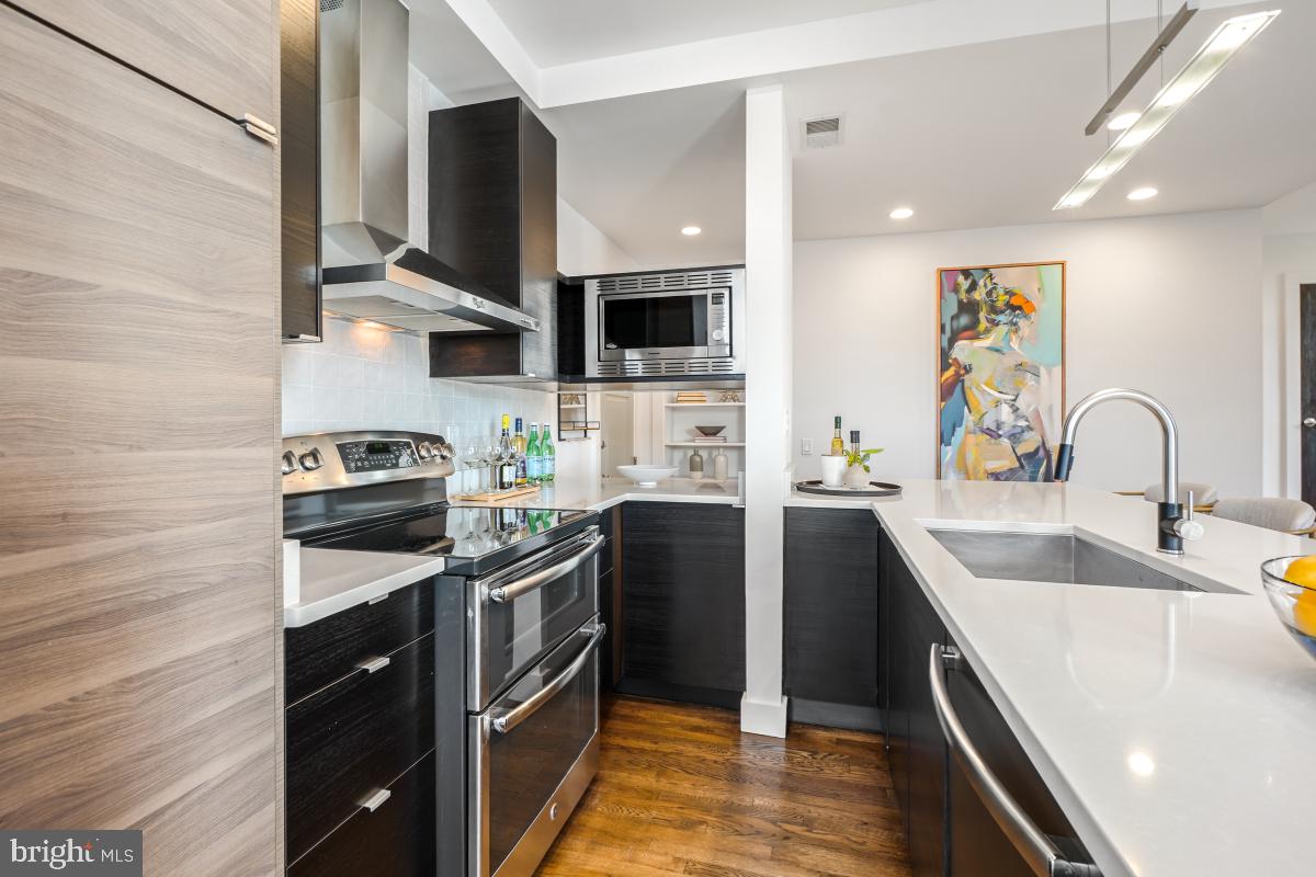 2107 S Street Northwest, Unit M Washington, DC 20008 - Photo 8 of 30 a kitchen with stainless steel appliances a sink stove and refrigerator