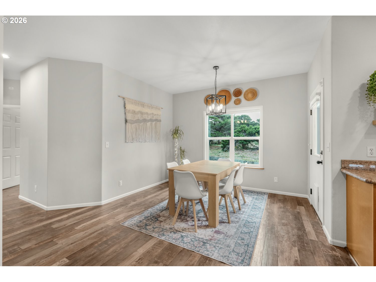 2927 Ruby Court Bandon, OR 97411 - Photo 14 of 38 a view of a dining room with furniture a chandelier and wooden floor